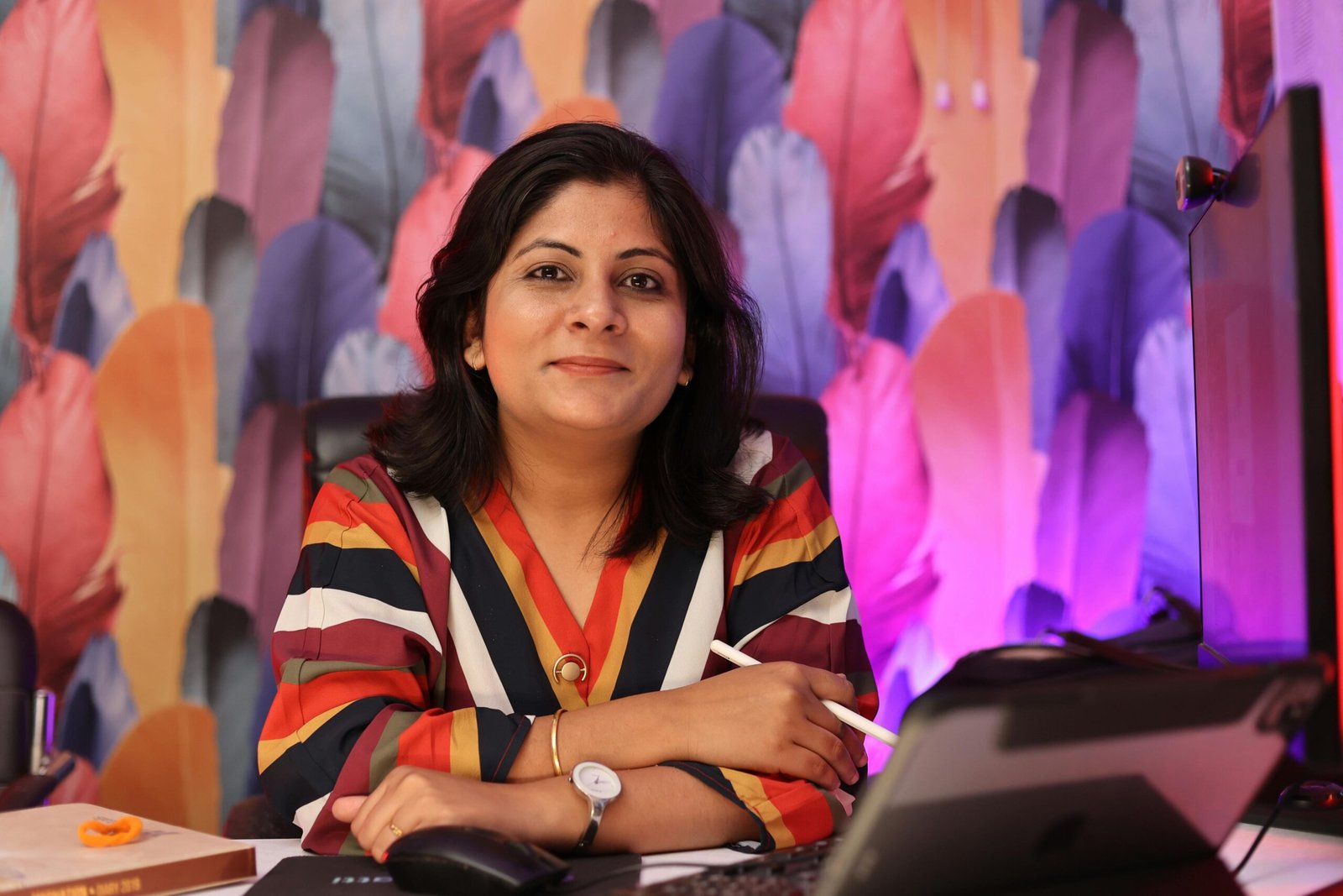 Home Confident woman in colorful office with graphics tablet, smiling at camera.